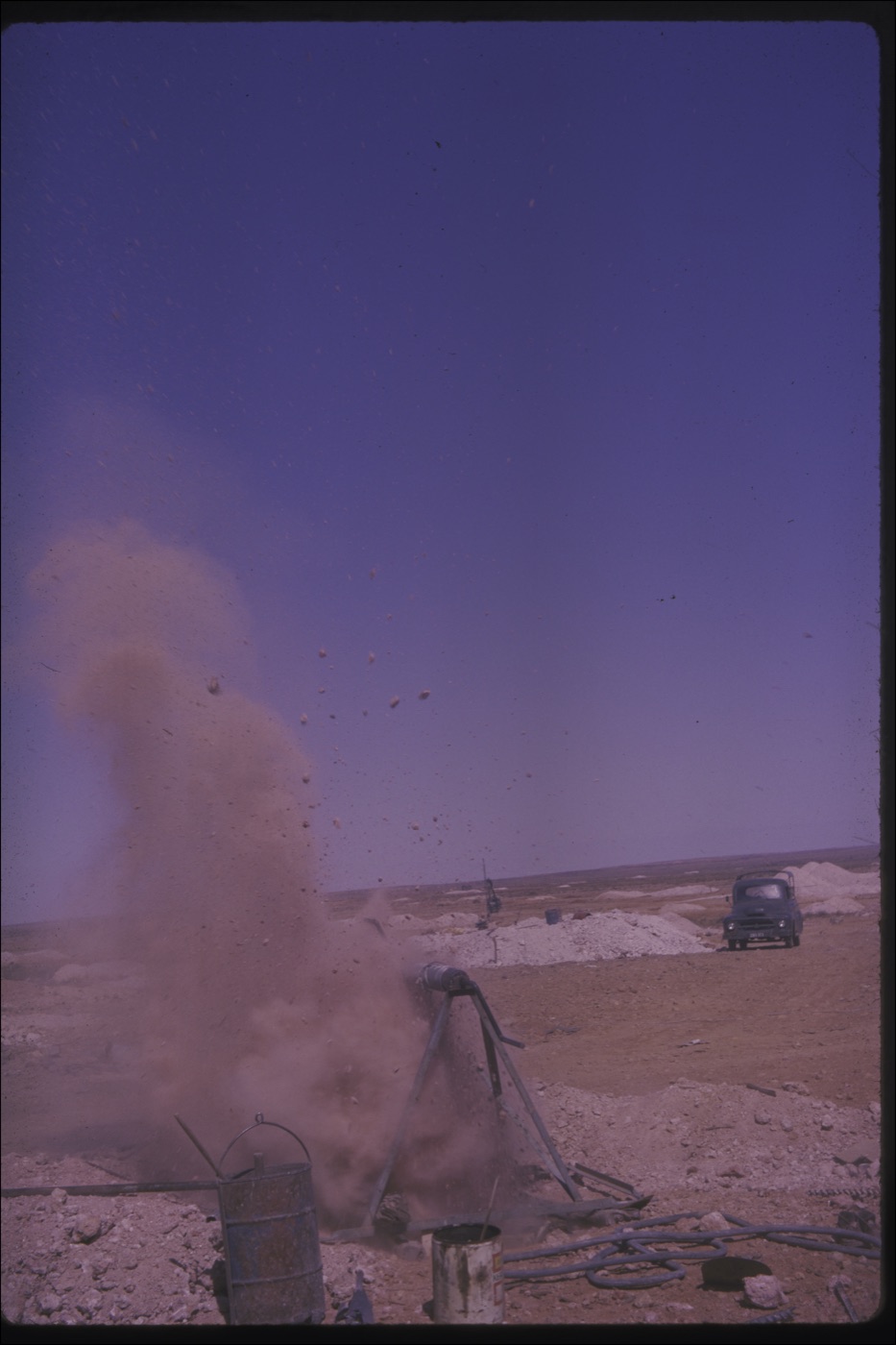 A blasting charge firing on the Coober Pedy opal field, debris in the air, photographed by Emmanuel Christianos