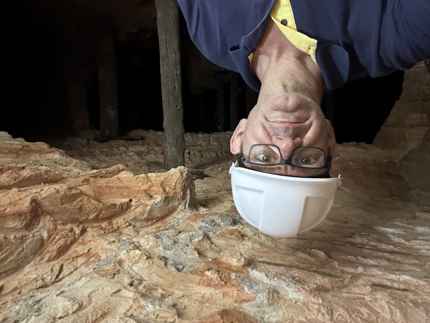 George Christianos underground in the family's opal mine at Lightning Ridge, hard hat on, timber props behind