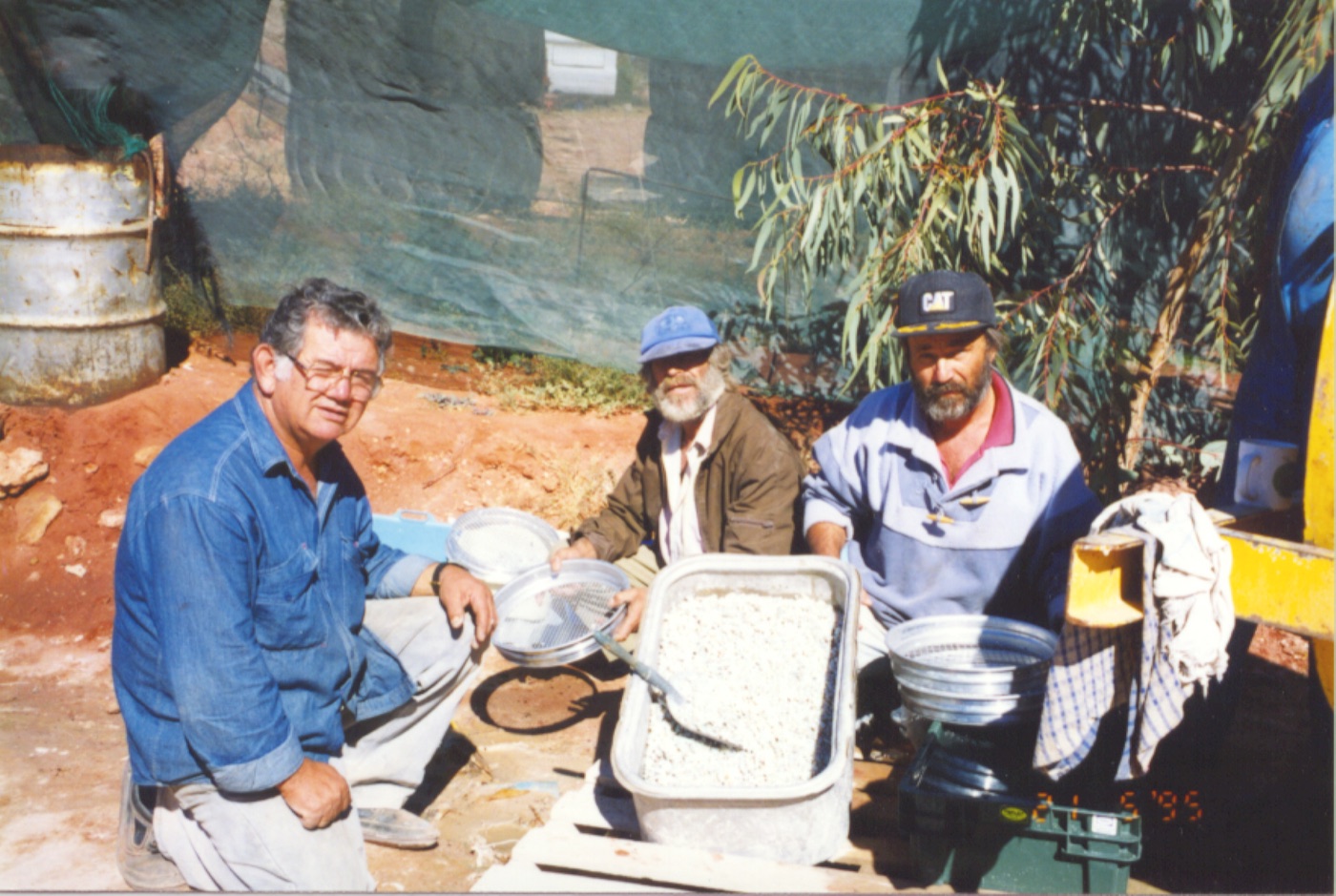 Emmanuel Christianos and crew washing opal chips in trays under shade cloth at the Mintabie camp, 1995